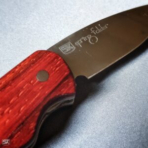 Spring folder knife with padouk handle scales metal etching detail view