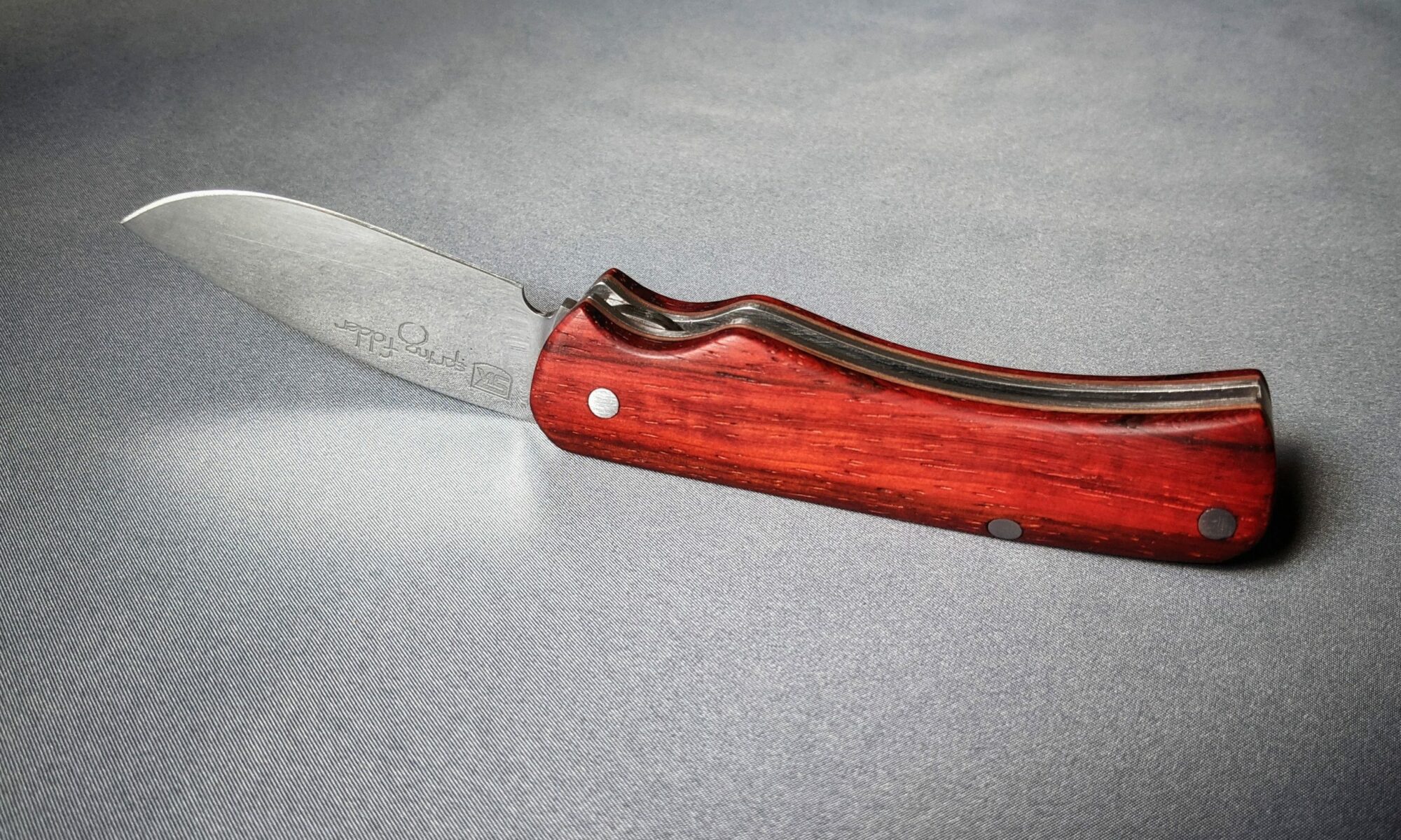 Spring folder knife header image with padouk handle scales