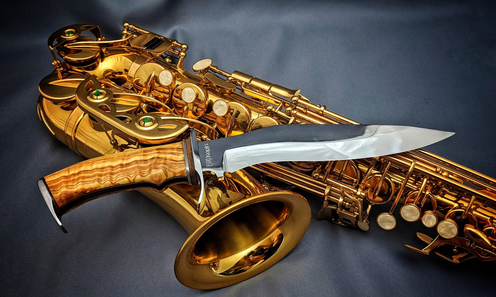 Beauty shot of a Kopis style handmade knife in front of Saxophone full width