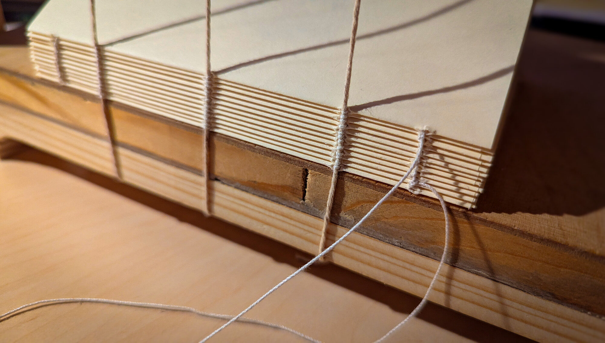 Closeup view of hand sewing and handbinding a book in a bookbindery